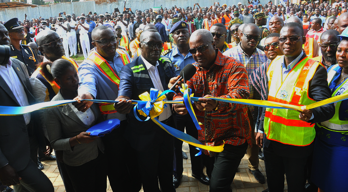  President Mahama being assisted by Mr Anamoo to cut the tape to officially inaugurate the Revenue Centre. Also in the picture are Mr Fiifi Kwetey (right) Minister of transport and Mr Samuel Ofosu Ampofo (3rd left) Board Chairman of GPHA.